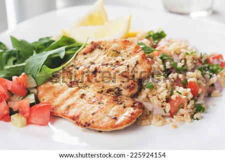 Grilled chicken meat with bulgur wheat and rocket salad