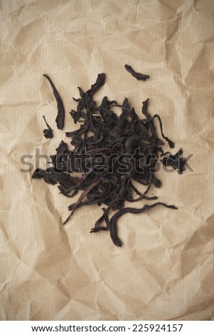 Dried black tea leaves on packaging paper
