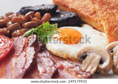 Full english breakfast with fried eggs, bacon, mushrooms, sausage and kidney beans