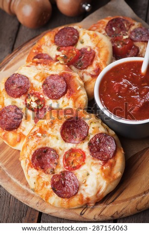 Mini pizzas with salami, cheese and tomato