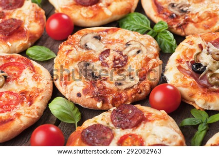 Mini pizzas with mushrooms, salami, cheese and tomato