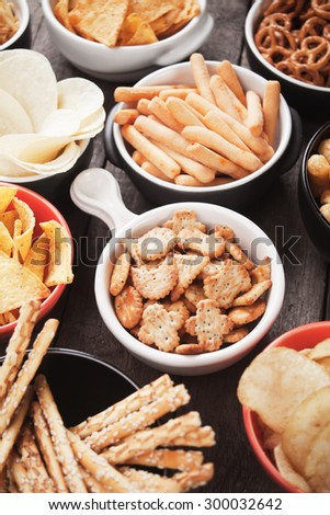 Salty crackers, tortilla chips and other savory snacks with salsa dip