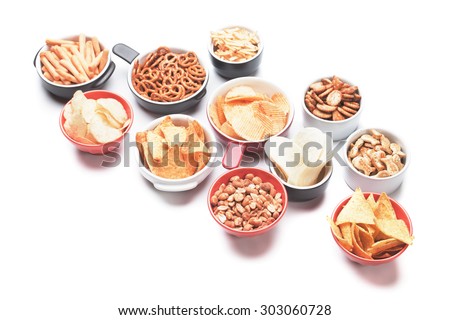 Salty crackers, tortilla chips and other savory snacks isolated on white background