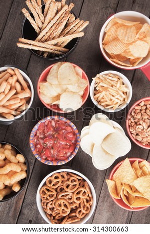 Salty crackers, tortilla chips and other savory snacks with salsa dip