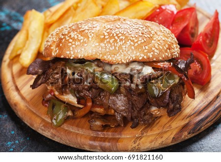 Philly cheese steak sandwich with tomato and french fries