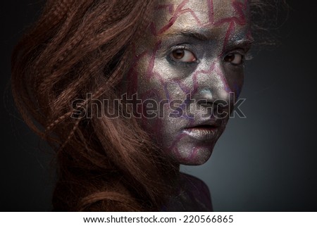 Beautiful face of a woman covered in glitter Close up of a woman\'s face covered in silver glitter