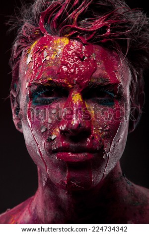 A creepy portrait of a halloween man with bloody body art and face art.