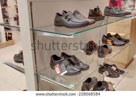 KIEV, UKRAINE - OCTOBER 7: A lot of women and man shoes in Munchen shop, on a glass shelf in a long hall of a shoe store with inscriptions Sale, OCTOBER 7, 2014 in Kiev, Ukraine