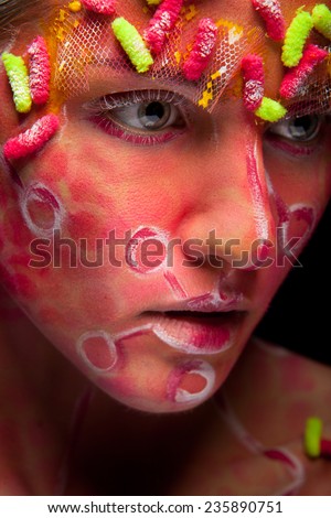 Bright face art and body art. Pretty woman portrait with paint on face. Creative make up