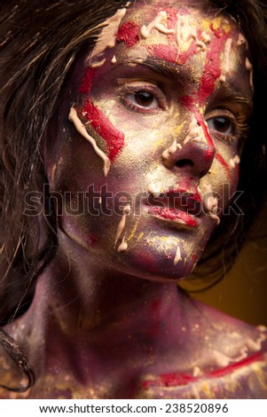 Woman with paint on face. Portrait of girl with black hair. Color paint on face