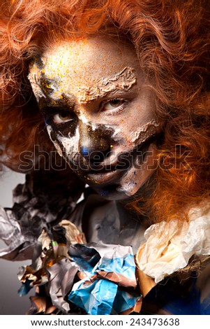 Red haired woman with face art and creative make up. Curly hair style. Black and white face art. Fantasy painted girl. Masquerade