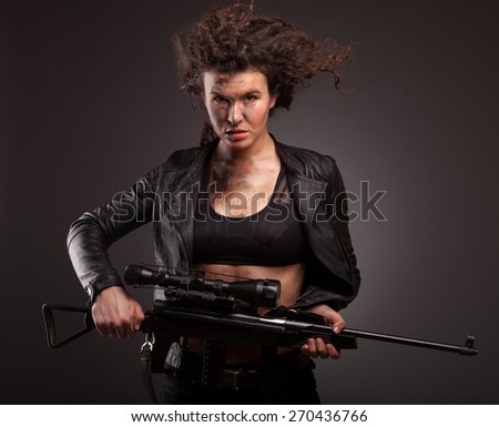 Sexy military woman posing with sniper gun. With blood, dirty face and wound.
