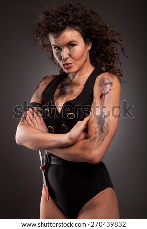 Beautiful young athlete woman with military style clothing and dirty face, wound and blood.