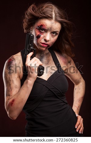 Beautiful sexy girl with gun. Posing in studio. With blood on face and wound.