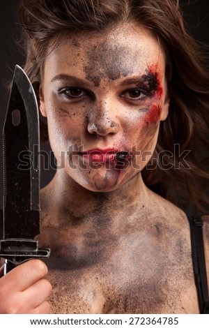 Sexy girl holding a knife. Woman with blood on face.