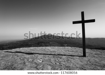 dark cross with mountain in background
