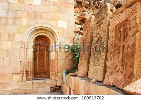 Cross-stones at Noravank monastery in Armenia, red rocky mountains.