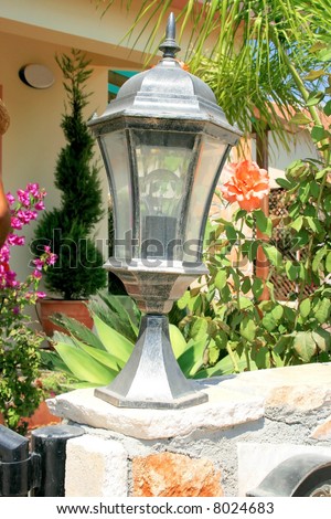Garden lamp on a low garden wall.