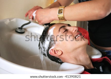 Hairdresser washing  teens hair in beauty saloon.