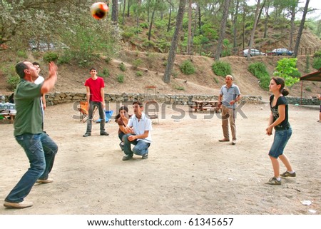 Group of young people playing ball in the forest.