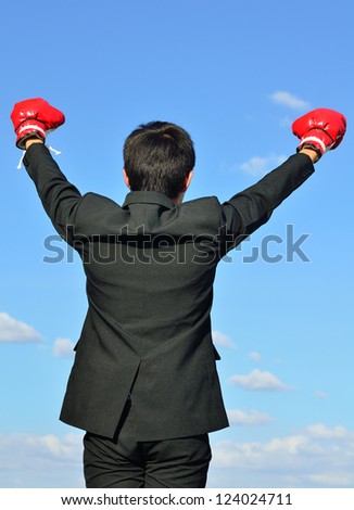 businessman and hand boxing glove ready to fight over blue sky