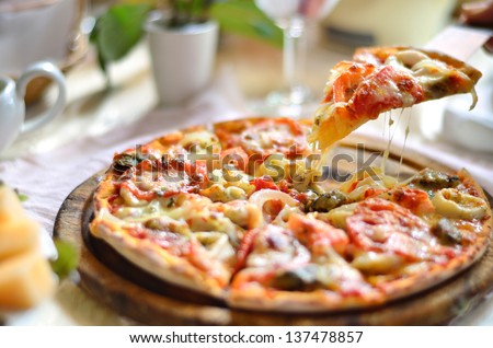 Seafood Italian Pizza slice on wood dish (originality)