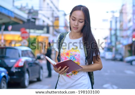 Close up woman tourism traveling in Thailand with map and guide book