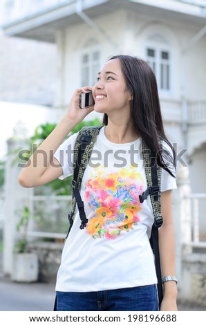 Close up Asian women walking to travel and call her friend with mobile phone