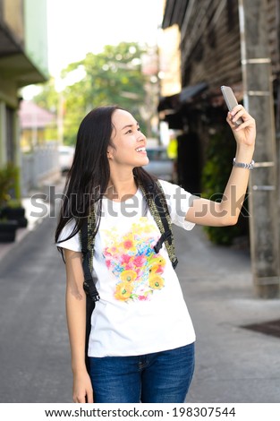Close up Asian women walking to travel and take a photo with mobile camera