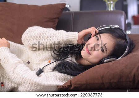 Sleeping shot of Asian woman teenager listing love music with big headphone.