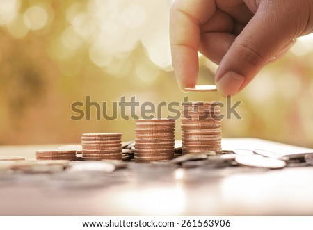 Save,Wealth,Saving money concept,Male hand putting money coin stack growing business with sunlight