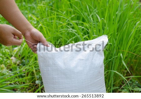 Farmer hand unpacking plant fertilizer bag