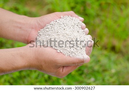 fertilizer,farmer hand holding plant chemical fertilizer over green background