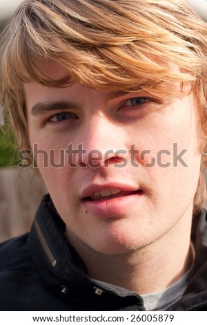 stock photo : A male model with blonde and brown hair looks directly at the