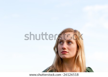 A female model looks up and away while being photographed in a way where there is extra room for text or copy space.