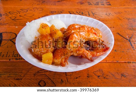 A nice plate of shrimp, rice and pineapple or garlic with rice and coleslaw in Hawaii.