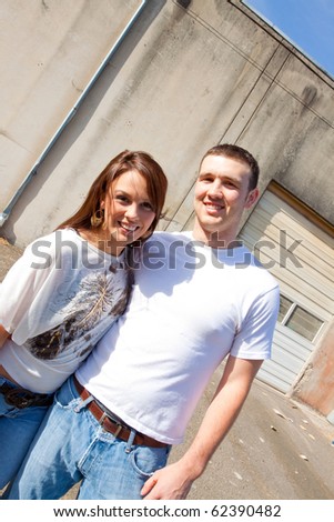 A young couple poses for some engagement photos in urban outdoor settings.