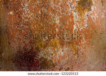 An old wooden chair has peeling paint on it to create an interesting abstract texture.