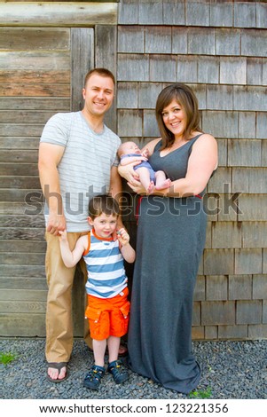 This family of four includes a mom, dad, 5 year old son, and a newborn son.