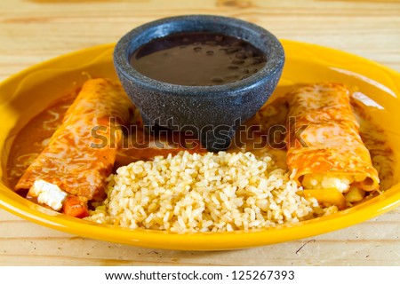 Enchiladas and rice and beans at a Mexican restaurant serving authentic cuisine.