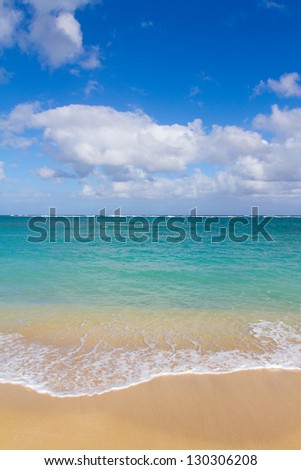 Beautiful tropical blue green water and a white sand beach on the north shore of Oahu in Hawaii. This image shows tropical paradise with a vacation getaway theme in a simple image.