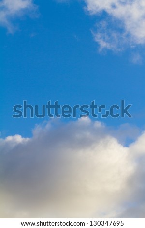 This abstract image of some blue sky and puffy clouds has plenty of copy space for design purposes. It is a very simple vibrant image of the sky.
