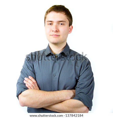 A young adult college student is photographed in the studio agains an isolated white background while wearing a grey shirt.