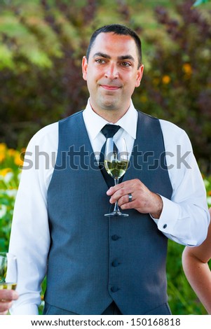 A groom reacts and enjoys the moment during the best man and maid of honor toasts at his wedding.