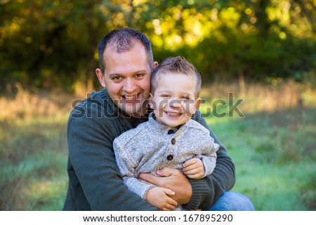 Dad and his son outdoors spending time together with the father and boy both looking happy.