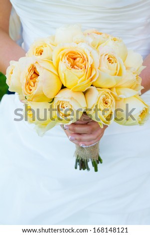 A beautiful bride in a white wedding dress holds her bouquet of flowers in her hand on her wedding day.