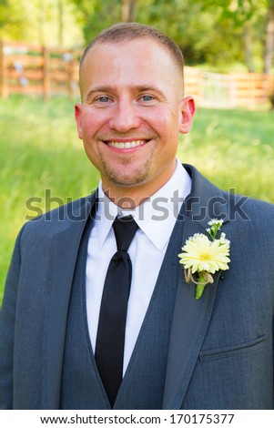 Male groom on his wedding day poses for a portrait before the ceremony looking formal and handsome.