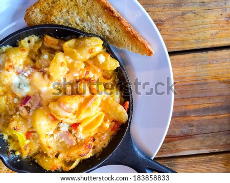 Fancy restaurant serves baked mac and cheese in a hot skillet with a side of Texas toast.