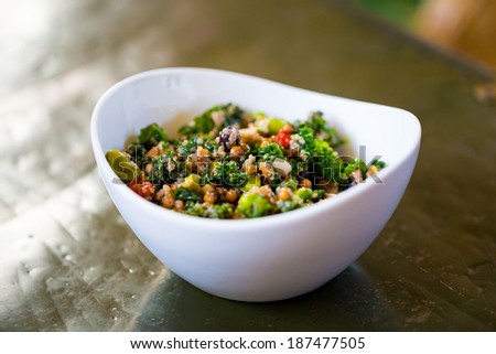 Raw paleo quinoa kale salad in a bowl. Healthy eating diet food.