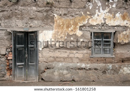 A weathered wooden door and window in a brick wall in a building in Cotacachi, Ecuador